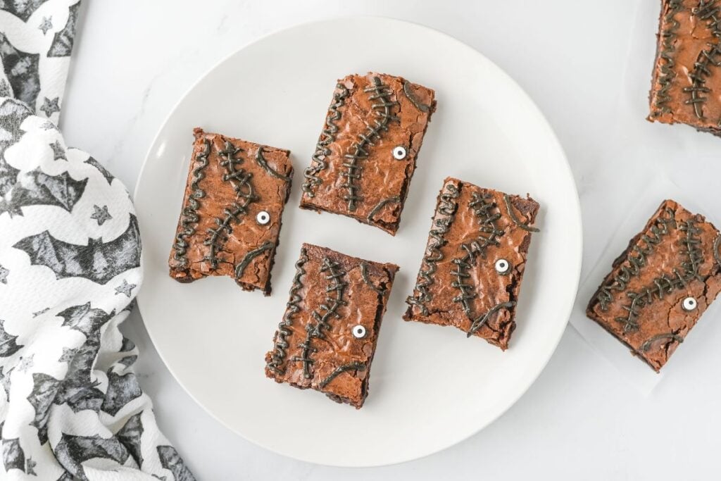 Four brownies on a plate.