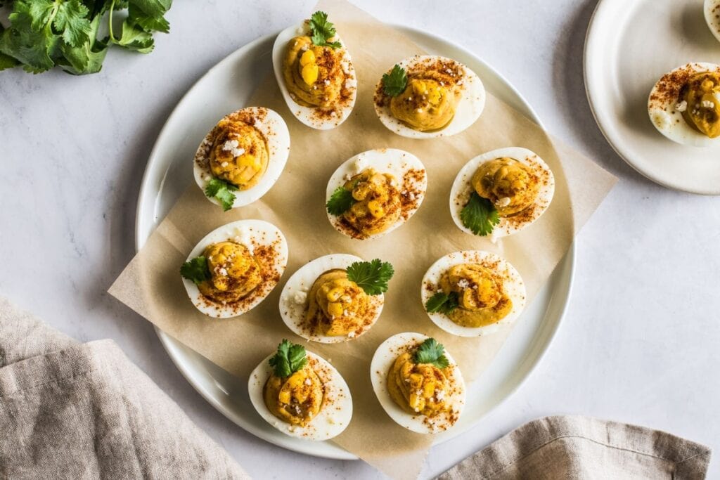 Mexican street corn deviled eggs on a white plate.