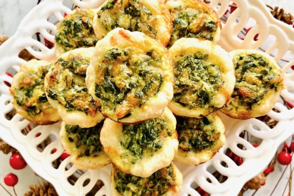 Mini quiche tarts on a white plate.