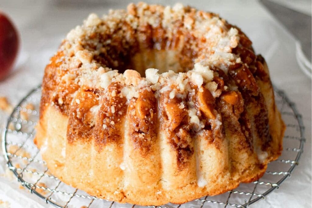 Whole peach cobbler pound cake on a cooling rack.