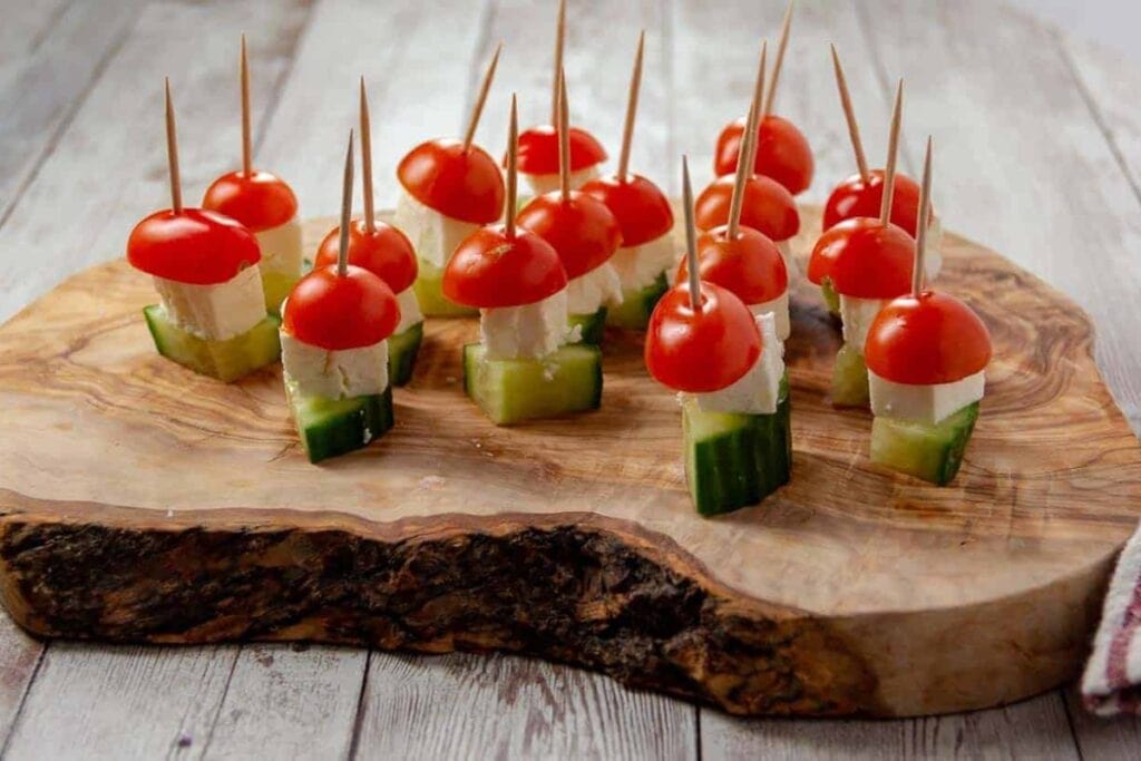 Salad on a stick on a wooden board.