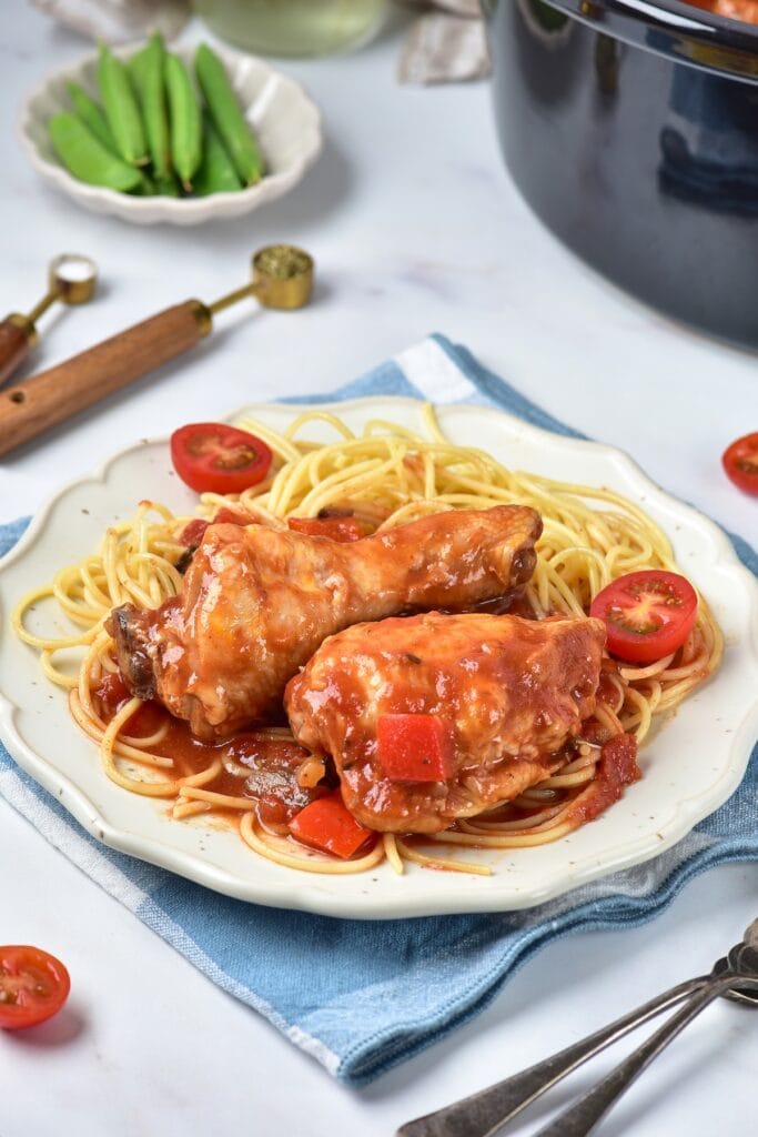 Chicken Cacciatore with pasta on a white plate.