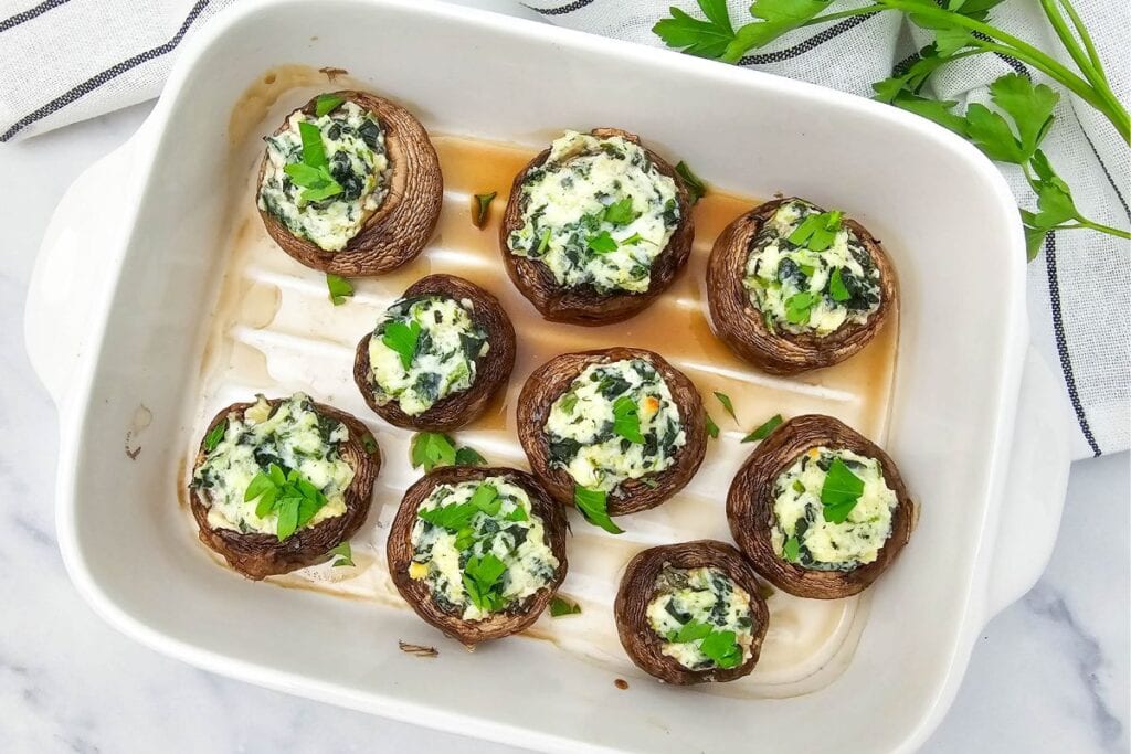 Stuffed mushrooms on a white rectangular baking dish.