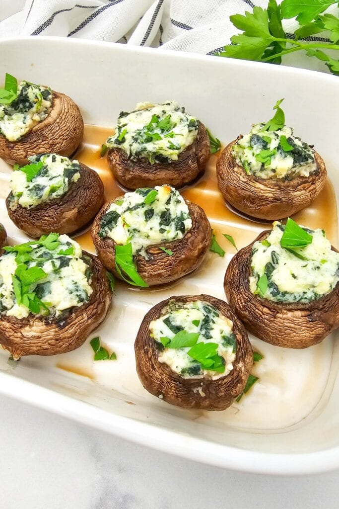 Stuffed mushrooms on a white rectangular baking dish.