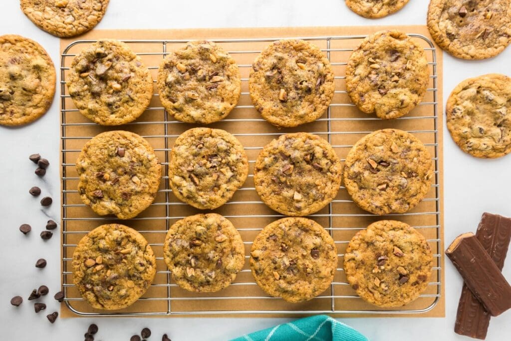 Toffee cookies with chocolate chips on a cooling rack.