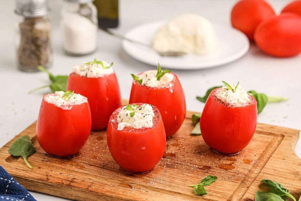 Tomato burrata bites on a wooden board.