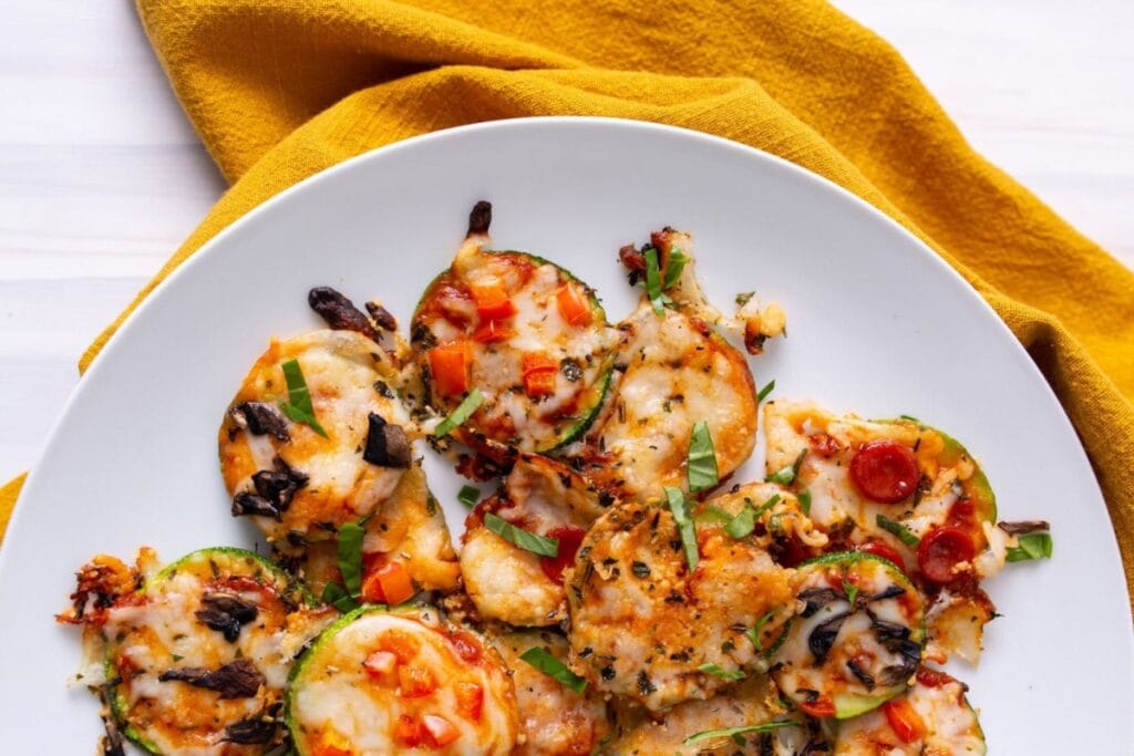 Zucchini pizza bites on a white plate.