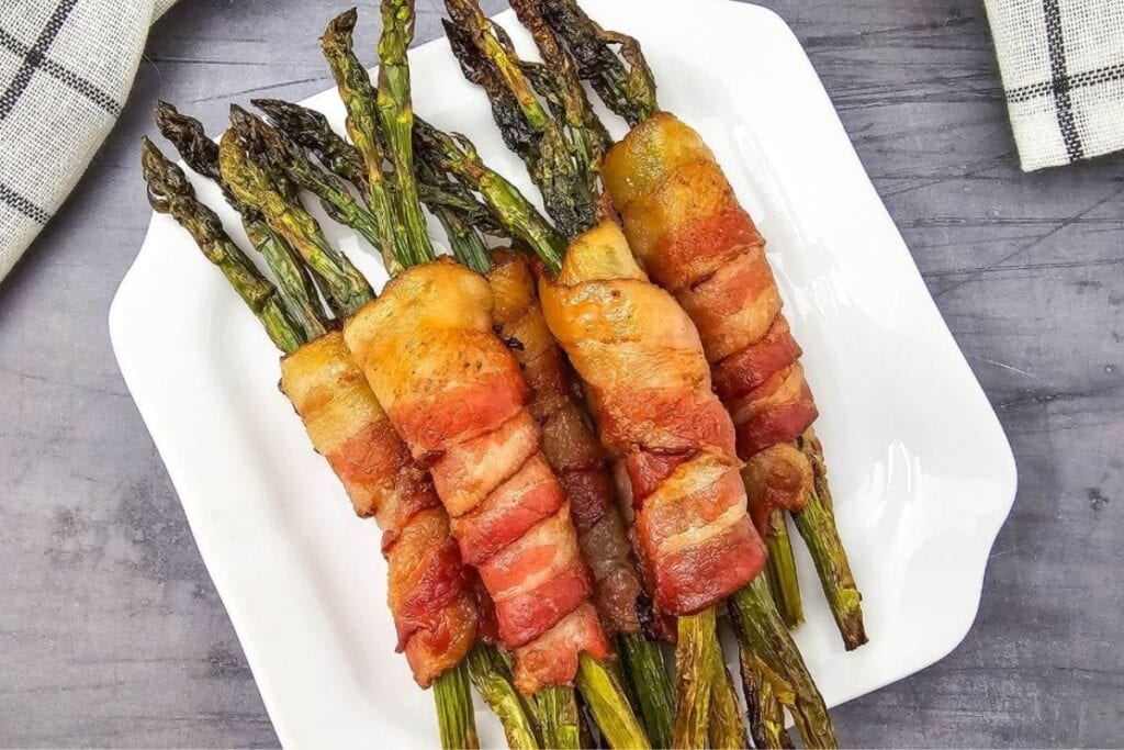 Bacon wrapped asparagus on a plate.