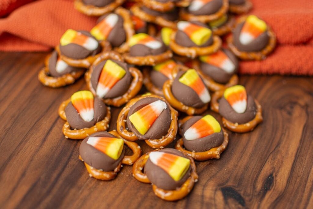 Candy corn pretzel hugs on a wooden surface.