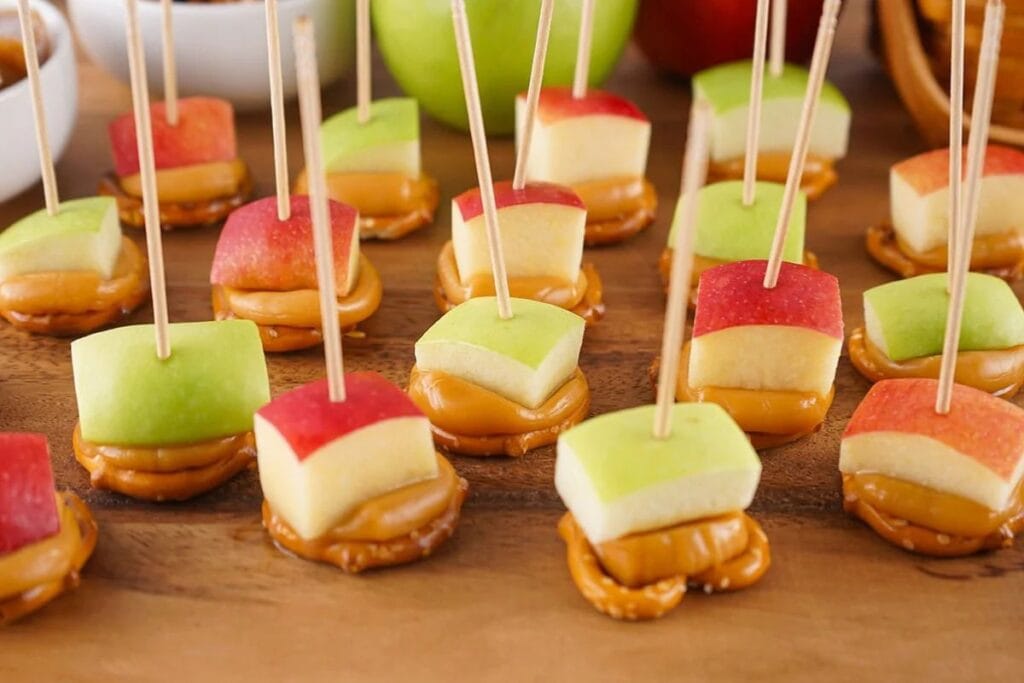 Caramel apple bites on a wooden surface.