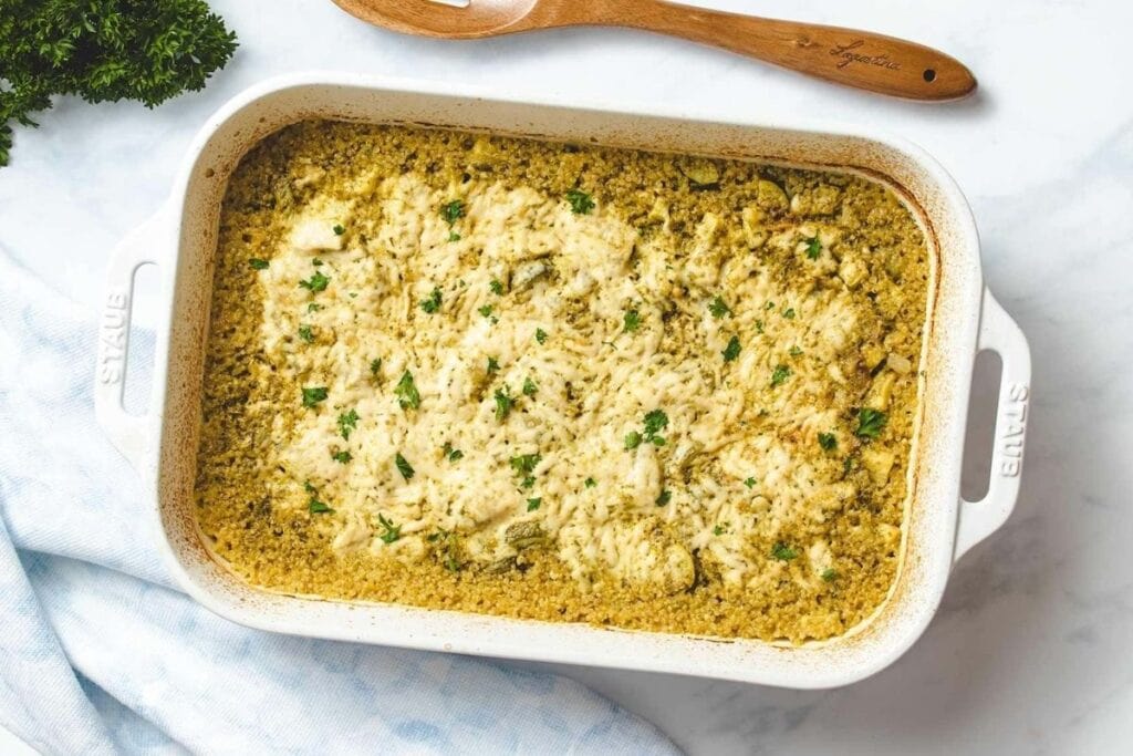 Chicken and zucchini casserole in a white dish.