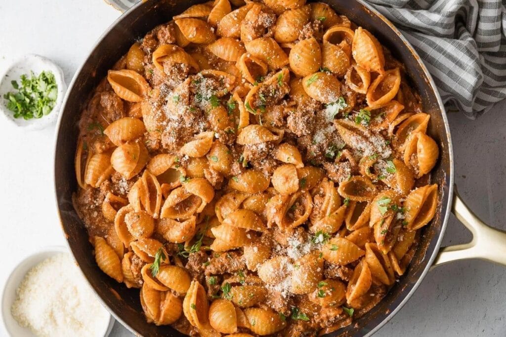 Chili garlic beef and shells in a pan.