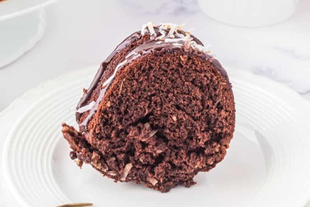 A slice of chocolate coconut bundt cake on a plate.