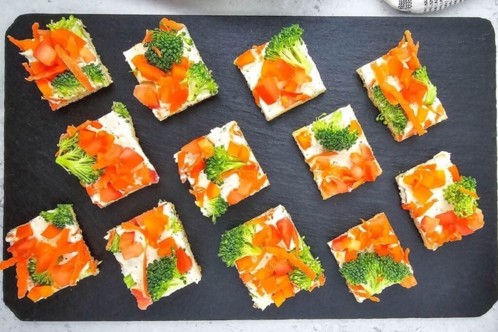 Veggie pizza on a black tray.