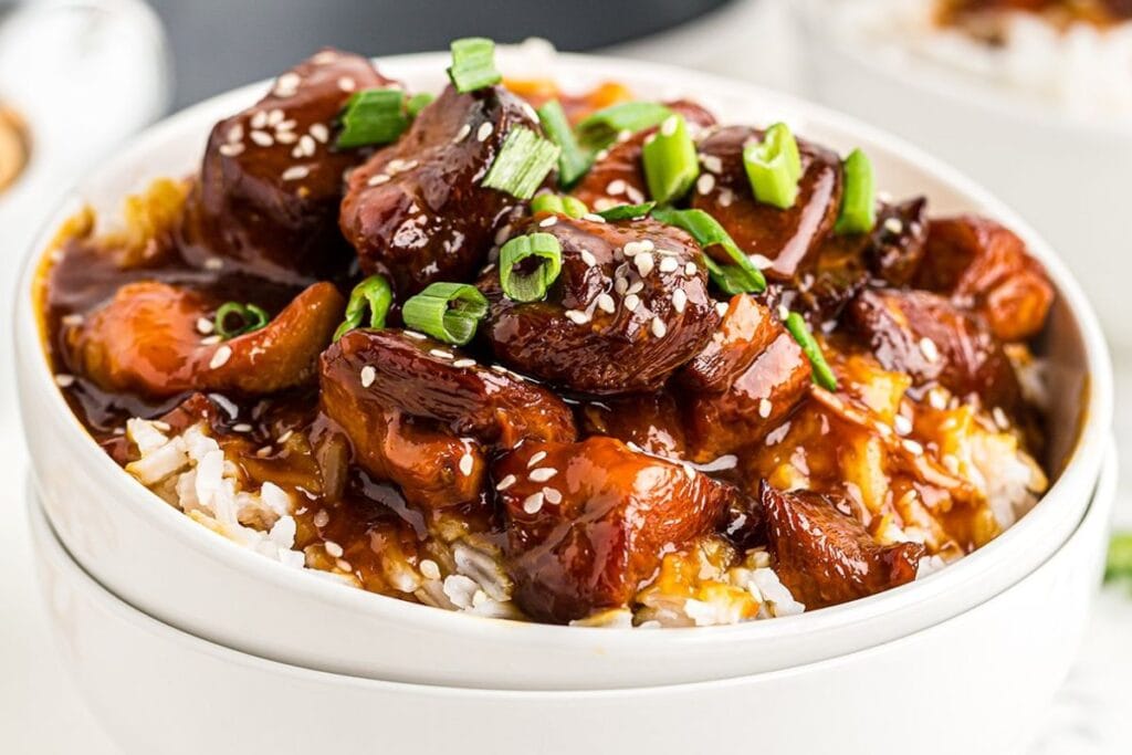 A bowl of sweet and sour chicken.