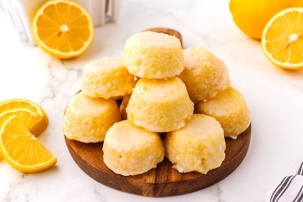 Lemon drop cakes on a wooden plate.