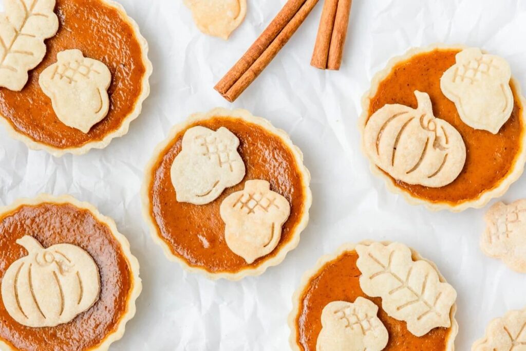 Mini pumpkin pies on a marble surface.