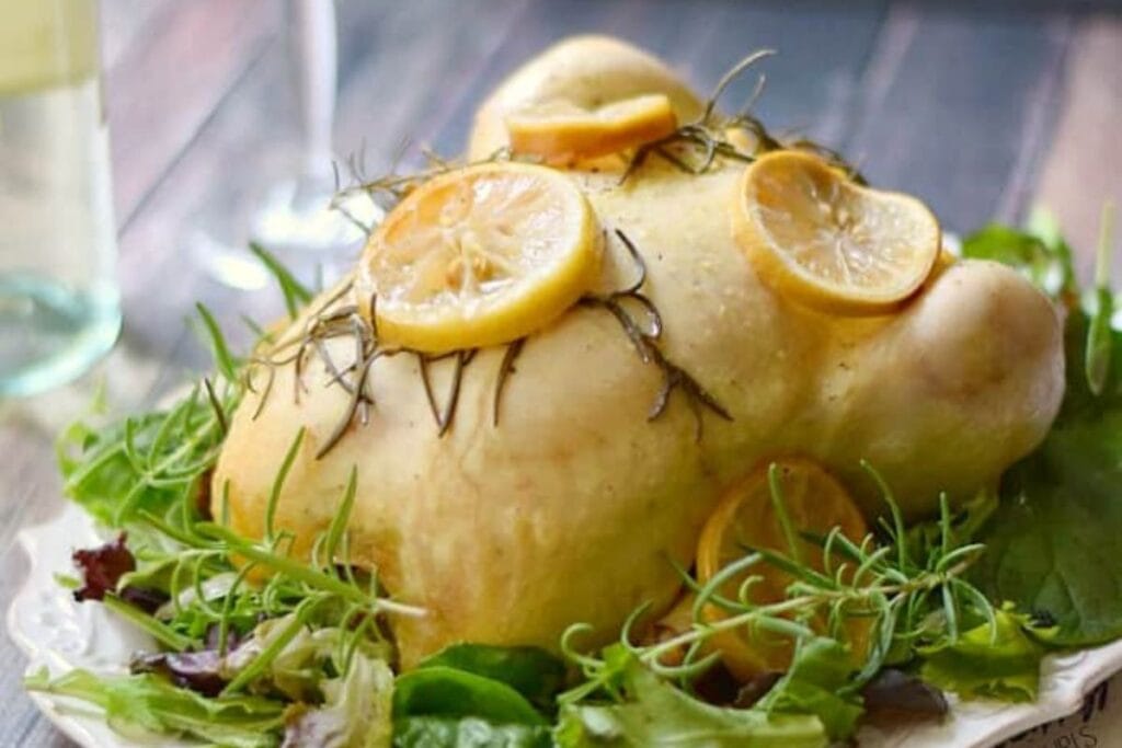 Chicken with sliced lemons and rosemary.