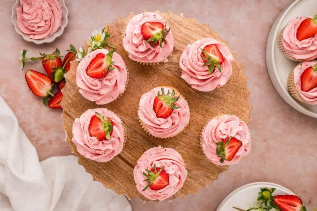Strawberry cupcakes on a wooden board.
