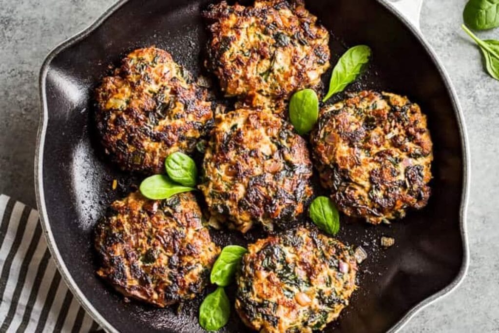 Turkey burgers in a pan.