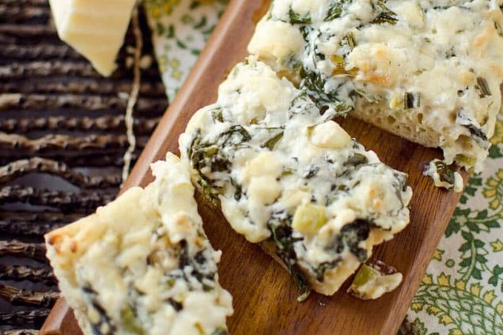 Spinach french bread on a wooden board.