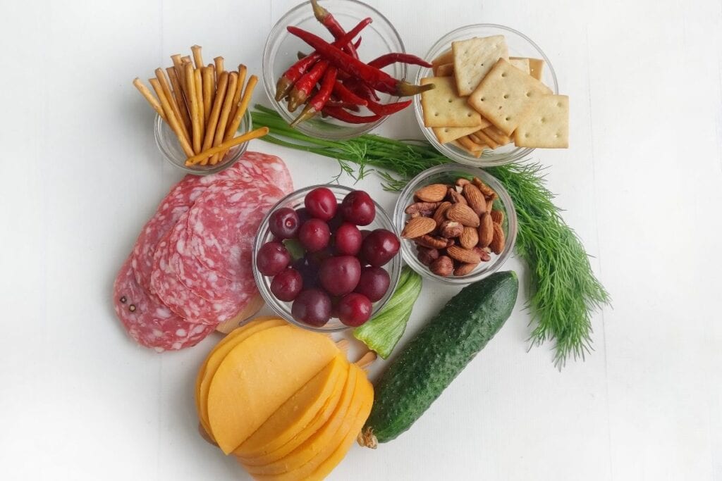 Ingredients for fall charcuterie on a white surface.