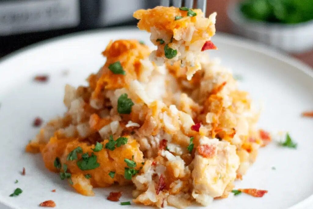 Bacon chicken ranch tater tot crockpot casserole on a white plate.