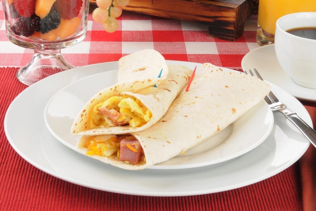 Basic breakfast burritos on a white plate.