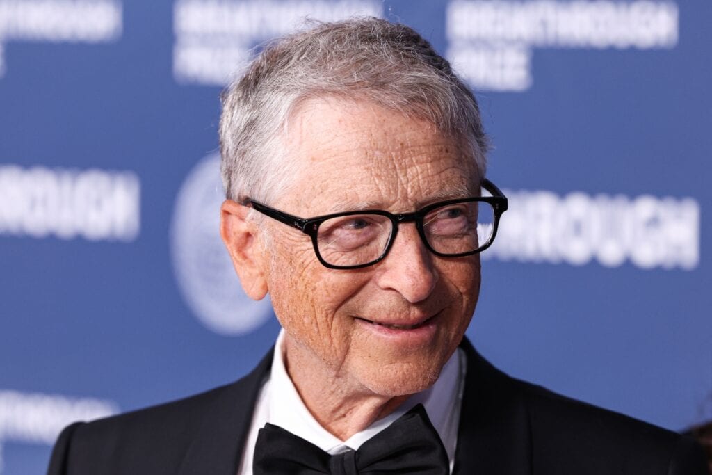 Bill Gates in a suit, side profile view.