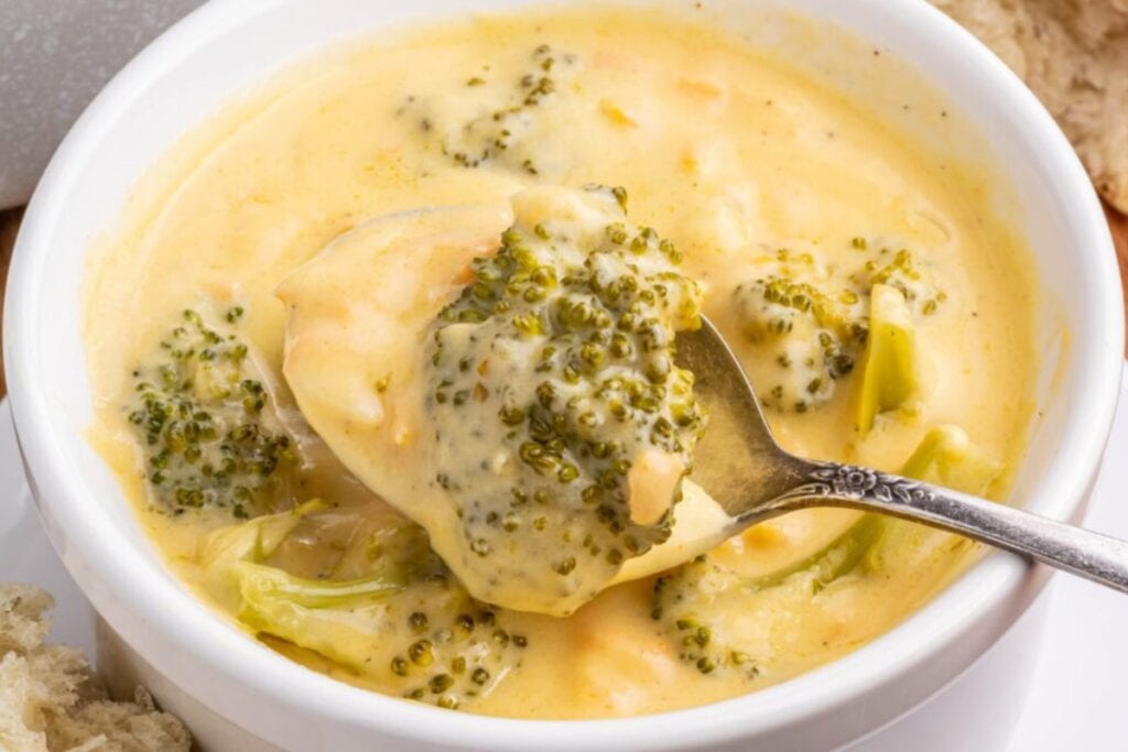 Broccoli cheddar soup in a white bowl with a spoon.