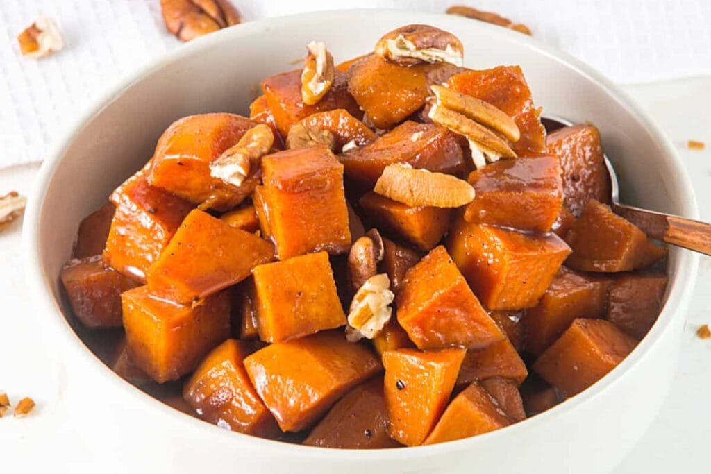 Candied sweet potatoes in a white bowl.