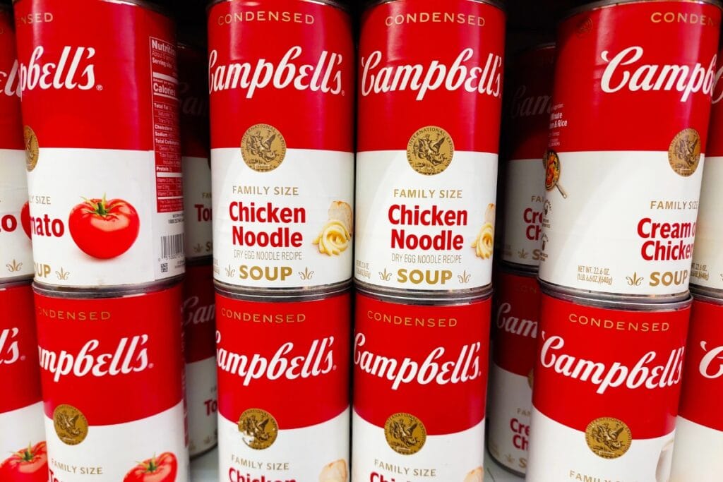 Canned soup arranged on a shelf.