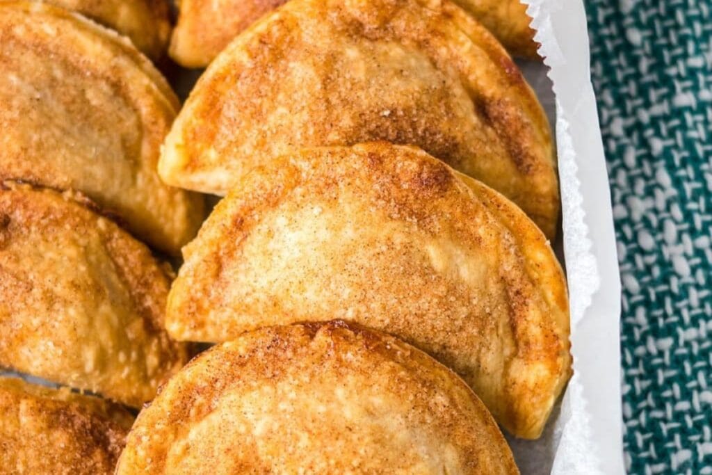 Caramel apple empanadas on parchment paper.