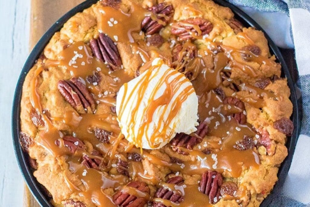 Caramel pecan cookie topped with ice cream and drizzled with caramel.
