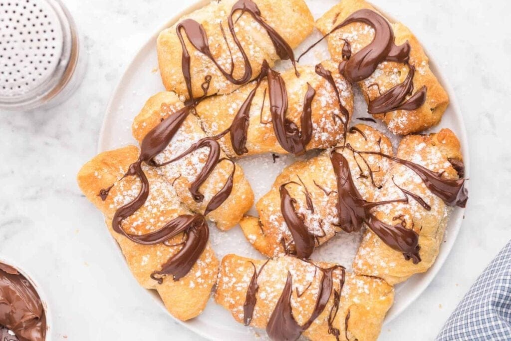 Chocolate croissants on a white plate.