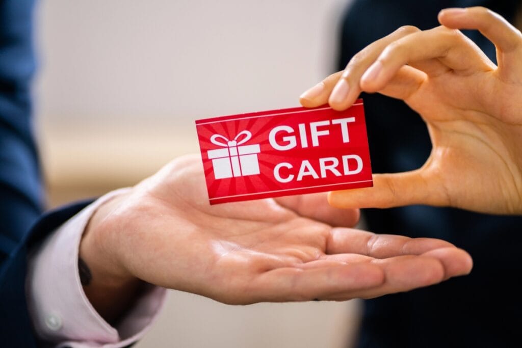 Hand holding a gift card, ready to use for extra savings during a sale.