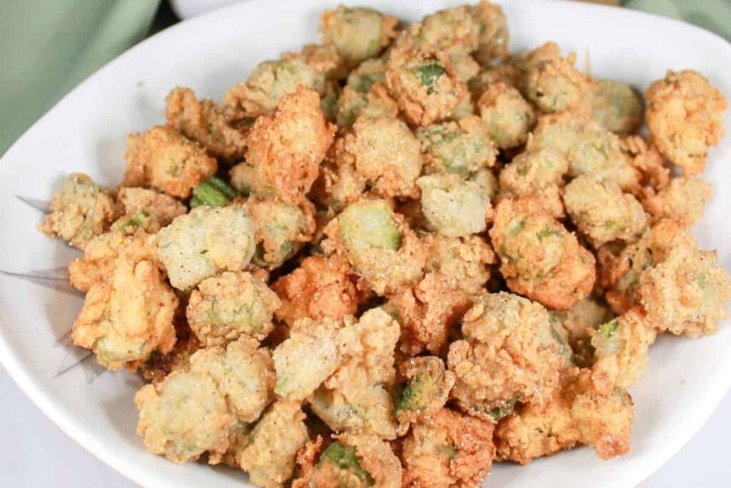 Crispy fried okra pieces served on a white plate.