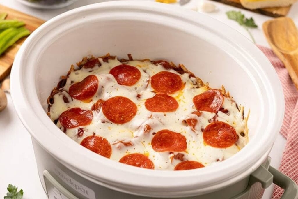 Pizza casserole cooked in a crock pot.