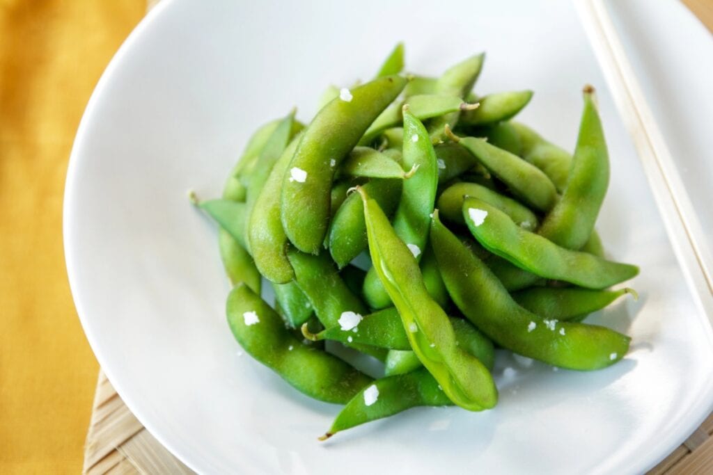 Edamame on a white plate.