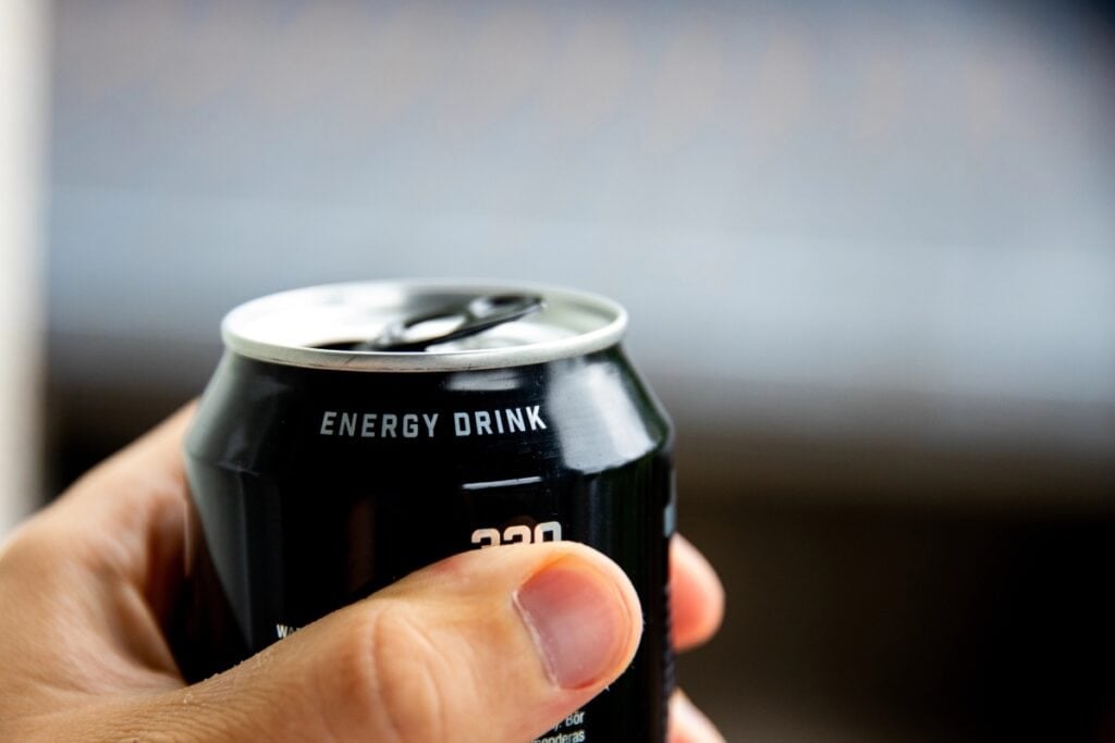 Person holding a can of energy drink.