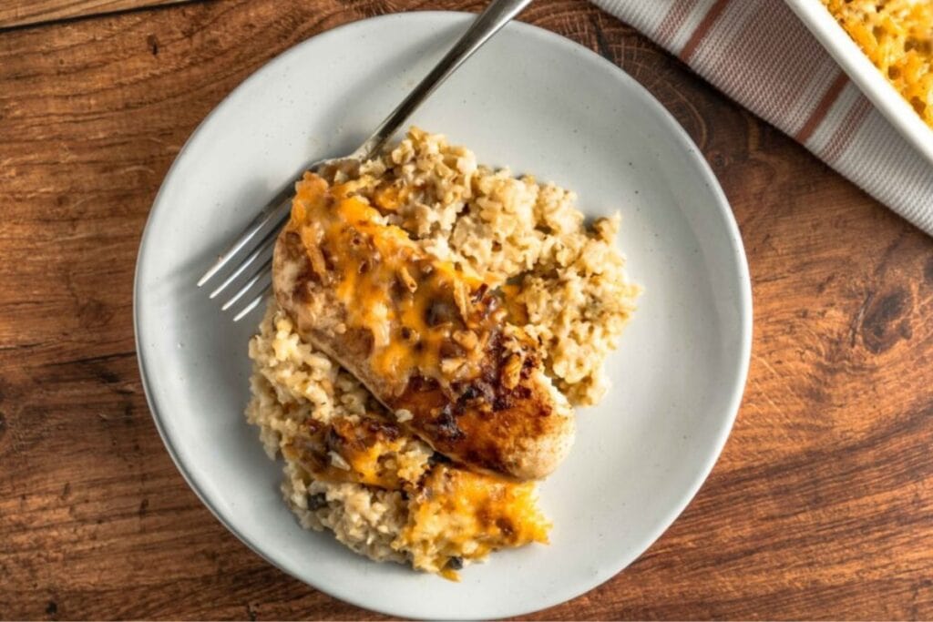 Forgotten chicken on a white plate with a fork on the side.