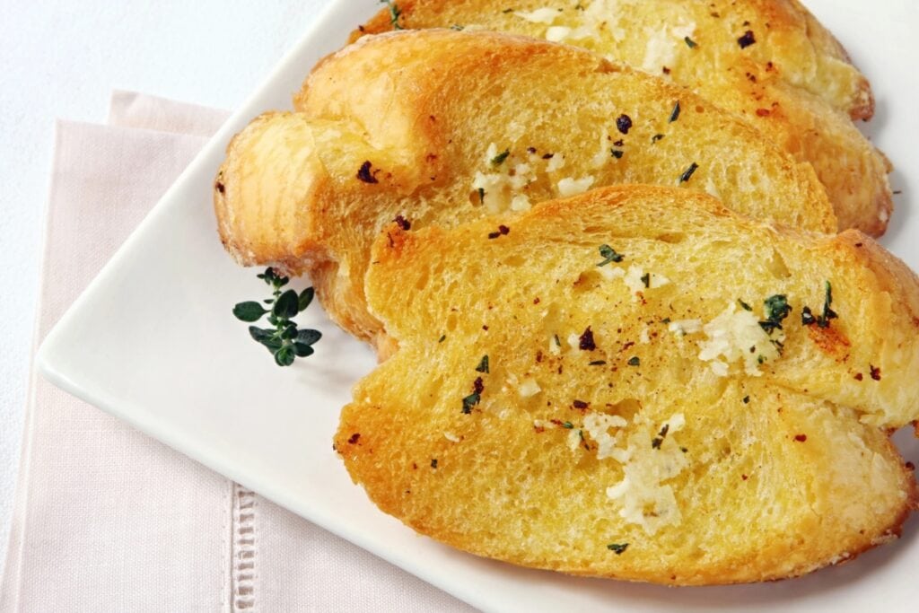 Garlic bread on a white plate.