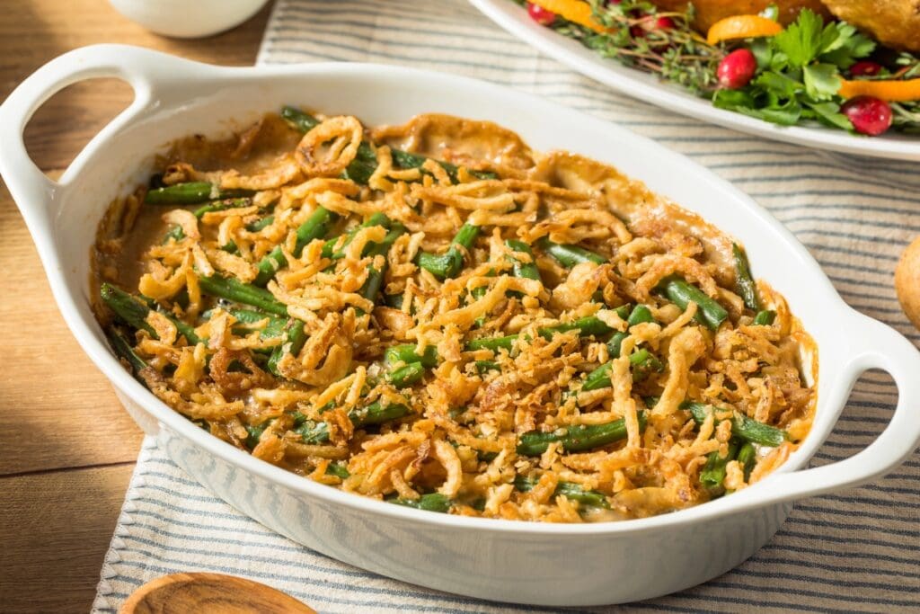 Green bean casserole in a white oval baking dish.