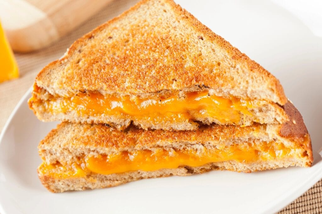 Grilled cheese sandwiches on a white plate.