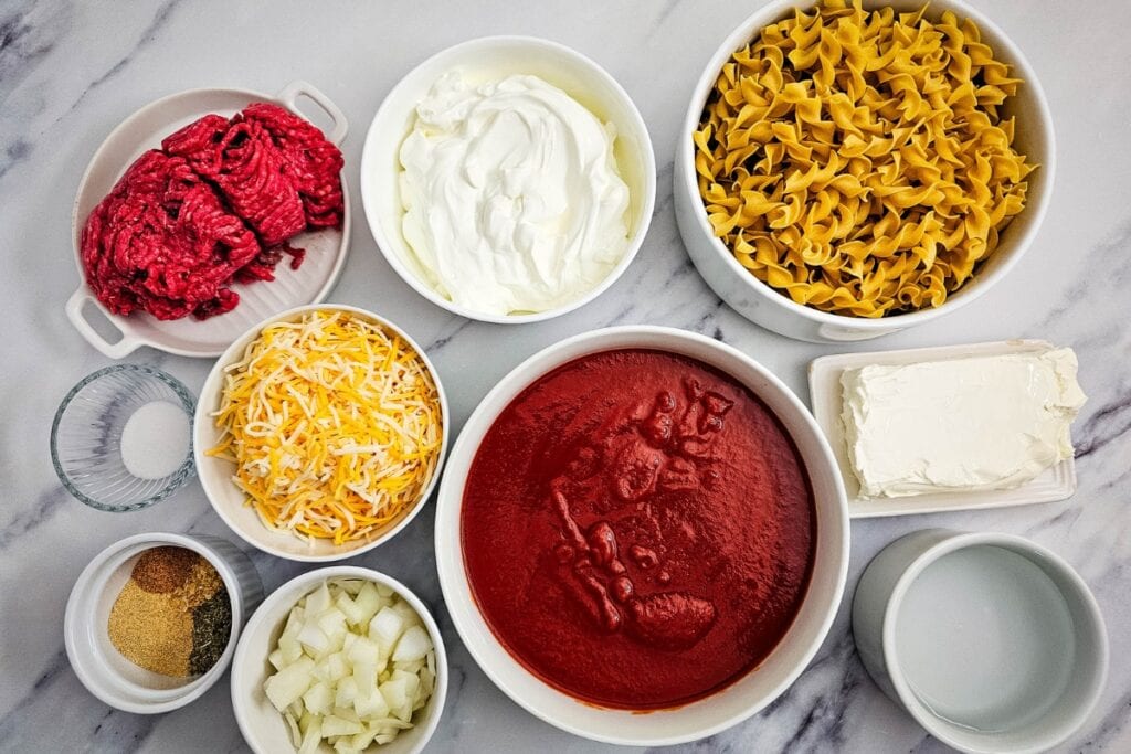 Ground beef casserole ingredients on a marble counter.