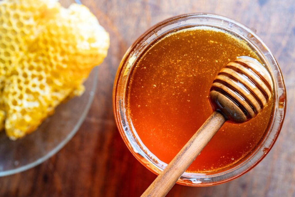 Honey with dipper and honeycomb.