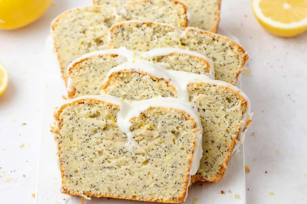 Lemon poppy seed loaf cake slices on a white rectangular plate.