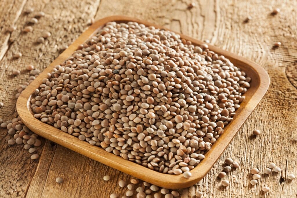 Lentils on a wooden square plate.