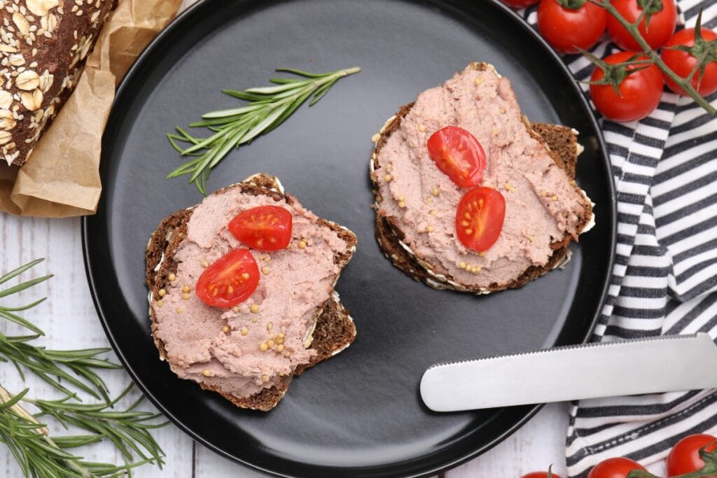 Liverwurst sandwiches served on a black plate.