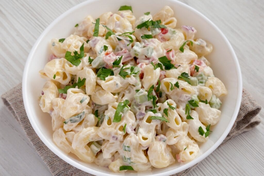 Macaroni salad in a white bowl.